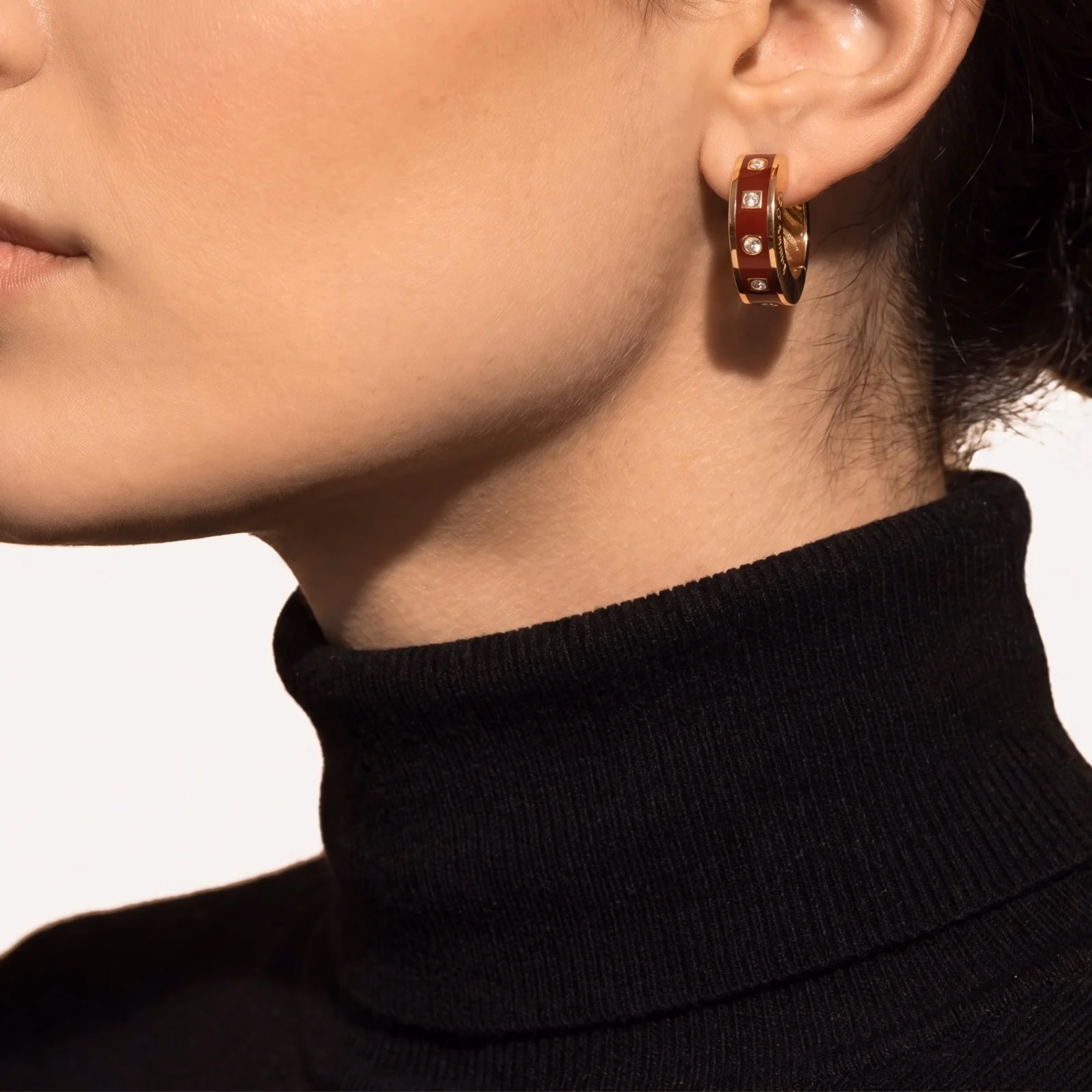 گوشوارهٔ حلقه‌ای مینای زرشکی روی گوش، نیم‌رخ